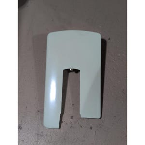May include: A smooth, off-white plastic sewing machine accessory cover featuring a rectangular shape with a U-shaped cutout at the bottom center. The component has a glossy finish and a curved top edge, designed as a replacement part for a machine.