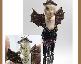 May include: A porcelain doll with wings, a crown, and a gear necklace. The doll is dressed in black lace and has a beaded fringe.