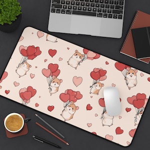 Op de afbeelding: Een rechthoekige muismat met een lichtroze achtergrond. Het heeft een patroon van cartoonhamsters die rode hartvormige ballonnen en verspreide rode harten vasthouden. Zwarte rand.
