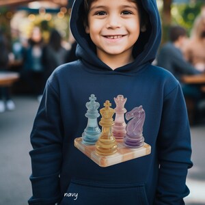 Può includere: Felpa con cappuccio blu navy con un design di pezzi degli scacchi colorati. La grafica include un re blu, un re giallo, una regina rosa e un cavallo viola su una scacchiera di legno. La parola "navy" è scritta in corsivo in basso.