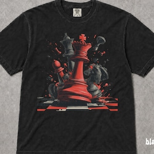 May include: A black short-sleeve t-shirt featuring a graphic print of a red chess queen piece surrounded by scattered black and red chess pieces on a checkered board. The design includes dynamic red splatters and a red cross atop the queen.