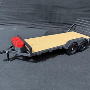 Könnte beinhalten: Ein Modell eines schwarzen und beigefarbenen Anhängers mit zwei Achsen und schwarzen Reifen. Der Anhänger hat eine Holzplattform und einen roten Behälter an der Vorderseite. Der Anhänger hat einen Metallrahmen und eine Heckklappe.