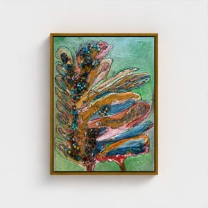 May include: Abstract painting in a gold frame, depicting a plant-like form. The artwork uses a palette of brown, blue, pink, and green. The painting has a textured surface with visible brushstrokes and embellishments, creating a unique visual effect.