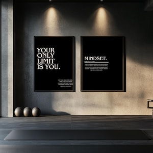 Könnte beinhalten: Zwei gerahmte Motivationsposter mit schwarzen Hintergründen und weißem Text. Eines lautet "YOUR ONLY LIMIT IS YOU." und das andere "MINDSET." Eine schwarze Yogamatte und drei graue Gymnastikbälle befinden sich im Vordergrund.