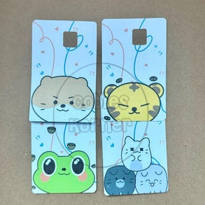 May include: Four rectangular cards with cartoon animal designs. Each card has a light blue background with pink and blue lines and small hearts. The animals include a hamster, tiger, frog, and three cats. Each card has the number "17" printed on it.