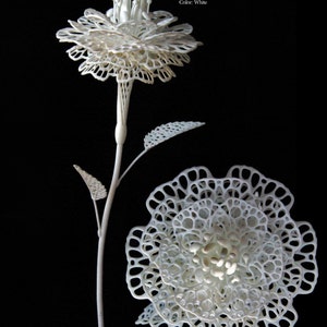 Puede incluir: Escultura de flor blanca impresa en 3D con un diseño delicado y de encaje. La escultura se titula "FIORE OTTAVO (#8)" y está hecha de poliamida (nylon). Mide 25 cm de diámetro.