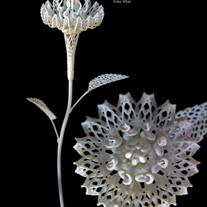May include: A white 3D printed flower sculpture with a delicate, intricate design. The flower is 10 inches tall and is made of SLS Polyamide (nylon).