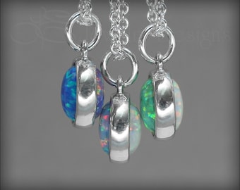 May include: Three silver necklaces with opal pendants. The opals are blue, white, and green.