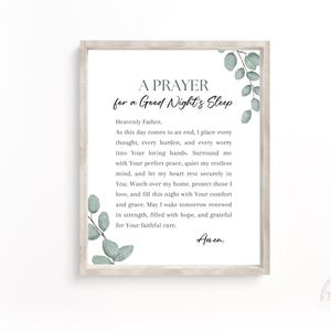 May include: A framed wall art print featuring the text A PRAYER for a Good Night's Sleep, followed by a prayer addressed to a Heavenly Father, ending with Amen. The design is decorated with green eucalyptus leaves in the top right and bottom left corners.