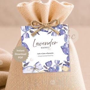 Könnte beinhalten: Ein beiger Jutesack mit einem Etikett mit der Aufschrift "Lavender Sachet". Das Etikett hat ein Aquarelldesign mit lila Lavendel-Illustrationen und den Worten "Soft, Calm, Romantic, A Sweet Scented Thank You."