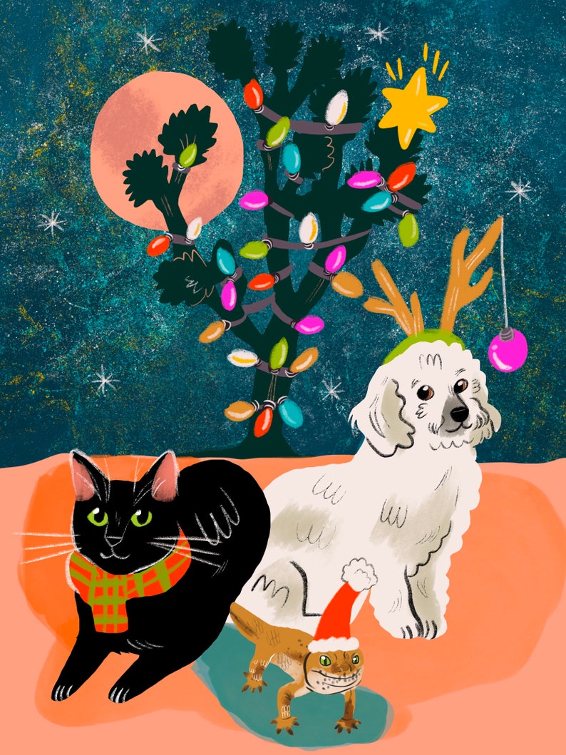 May include: A black cat wearing a red and black scarf sits next to a white dog wearing reindeer antlers and a red and white Santa hat. A small lizard wearing a Santa hat is in front of them. A Joshua tree with colourful lights is in the background.