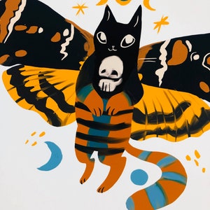 May include: A black cat with a skull on its chest, wearing butterfly wings with yellow, orange, and black stripes. The cat has a white face with black eyes and a small pink nose. The wings are spread out and the cat is flying in the air. There are small yellow stars and blue crescent moons in the background.