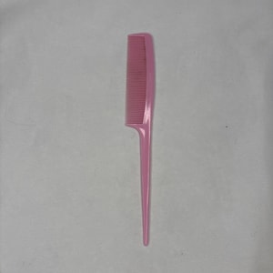 May include: A pink plastic comb with a long, pointed handle. The comb has fine teeth and is designed for styling and detangling hair. The handle is approximately 6 inches long.