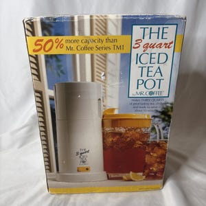May include: Box for a Mr. Coffee 3-quart Iced Tea Pot. The box is white and yellow with text that reads "50% more capacity" and "Makes THREE QUARTS of great tasting tea, chilled and ready to serve in about 10 minutes."