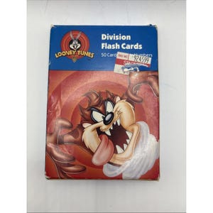 May include: A Looney Tunes Division Flash Cards box featuring Taz, the Tasmanian Devil, with a red and orange background. The box has the Looney Tunes logo and text that reads "Division Flash Cards" and "50 Card".