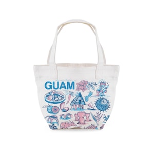 May include: White tote bag with blue and pink illustrations of Guam landmarks and the word "GUAM" in blue. The bag has two handles and is made of a canvas-like material. The illustrations include local food, flowers, and cultural symbols.