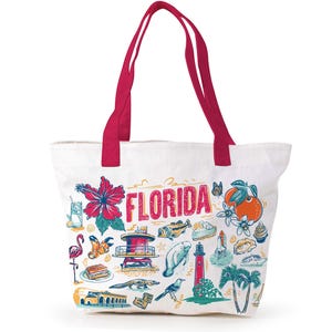 May include: White tote bag with red handles featuring a colorful illustration of Florida landmarks and the word "FLORIDA". The design includes a hibiscus flower, orange, flamingo, and a lighthouse.