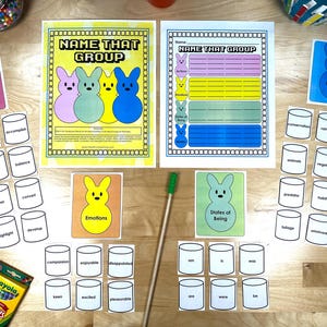 May include: Educational game with cards and worksheets. The game includes cards labeled "Actions", "Emotions", "States of Being", and "Wildlife". The worksheets are titled "Name That Group". A box of Crayola crayons is also visible.
