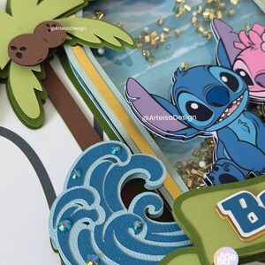 May include: A layered paper craft featuring a blue cartoon character, a pink cartoon character, a palm tree, and a blue wave with sparkling accents. The background includes a beach scene with gold confetti.