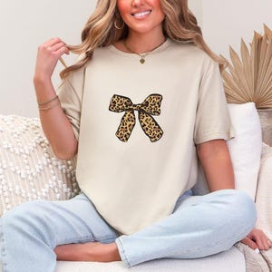 Leopard Print Bow Shirt | Bold Feminine Graphic Tee | Trendy Animal Print T-Shirt | Coquette with Edge | Girly Statement Top