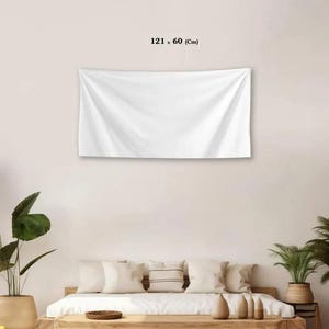 May include: A rectangular white wall tapestry hanging horizontally. The fabric features soft folds and a smooth texture. Above the tapestry, the text 121 x 60 (Cm) is printed in black, indicating the dimensions of the textile wall hanging.