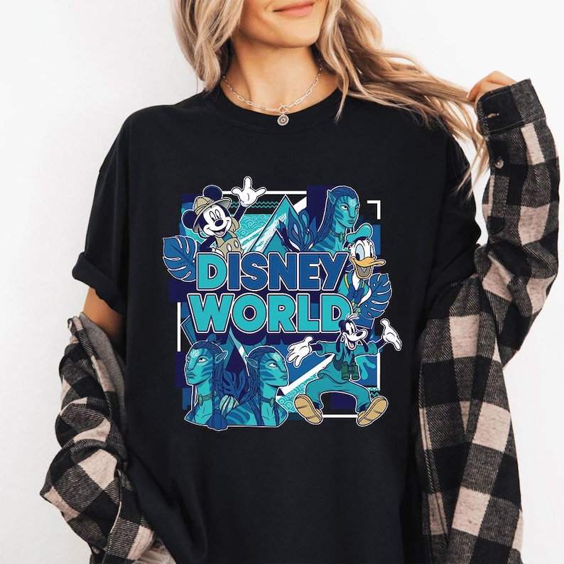 Puede incluir: Camiseta negra con un dise&ntilde;o gr&aacute;fico colorido. Las palabras "DISNEY WORLD" son azules, con im&aacute;genes de Mickey Mouse, el Pato Donald, Goofy y personajes de Avatar. El dise&ntilde;o es de estilo caricatura con acentos azules y verdes.