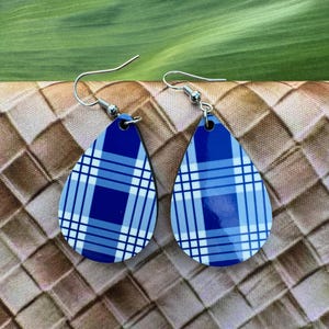 May include: A pair of blue and white plaid teardrop-shaped earrings with silver hooks.