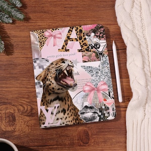 Könnte beinhalten: Ein rosa und leopardenmuster Notizbuch mit dem Text "pretty girls love pink!" und einer brüllenden Leopardenillustration. Das Notizbuch hat auch eine rosa Schleife, eine Discokugel und ein Martiniglas.
