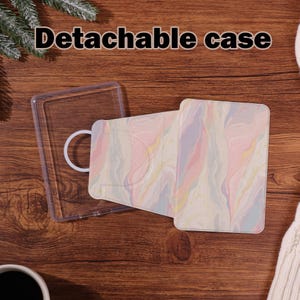Könnte beinhalten: Eine abnehmbare Hülle mit einer transparenten Kunststoffschale und einer gemusterten Abdeckung. Die Abdeckung hat ein pastellfarbenes Wirbeldesign in Rosa, Gelb und Lila. Der Text "Detachable case" wird oben angezeigt.