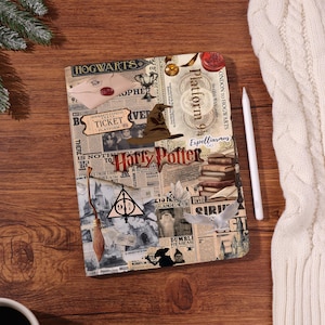 May include: A Harry Potter-themed notebook with a collage design. The cover features images of a ticket, the Sorting Hat, a broom, and the Deathly Hallows symbol. Text includes "Hogwarts", "Platform 9 3/4", and "Harry Potter". A white stylus and a white sweater are on the right.