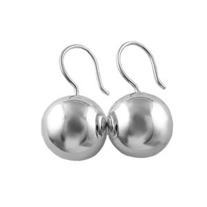 May include: A pair of polished silver ball earrings. Each earring has a smooth, spherical design suspended from a curved hook. The earrings reflect light, creating a bright, metallic appearance. The hooks are simple and elegant.