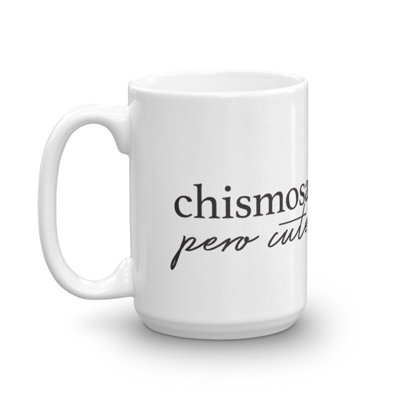 May include: White ceramic coffee mug with black text that reads "chismosa pero cute".