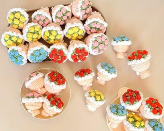 Può includere: Una collezione di bouquet di fiori all'uncinetto fatti a mano in vari colori, tra cui giallo, rosa, rosso e blu. I bouquet sono disposti su vassoi e piatti, mostrando la dettagliata maestria dei disegni floreali.