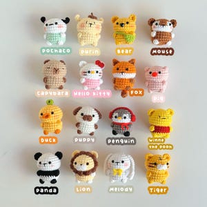 May include: A collection of 16 crocheted animal plushies, each with a unique design and color. The plushies are arranged in four rows of four, with the names of each animal written below them. The animals include a duck, a puppy, a penguin, Winnie the Pooh, a panda, a lion, a melody, a tiger, a pochaco, a purin, a bear, a mouse, a capybara, Hello Kitty, a fox, and a pig.