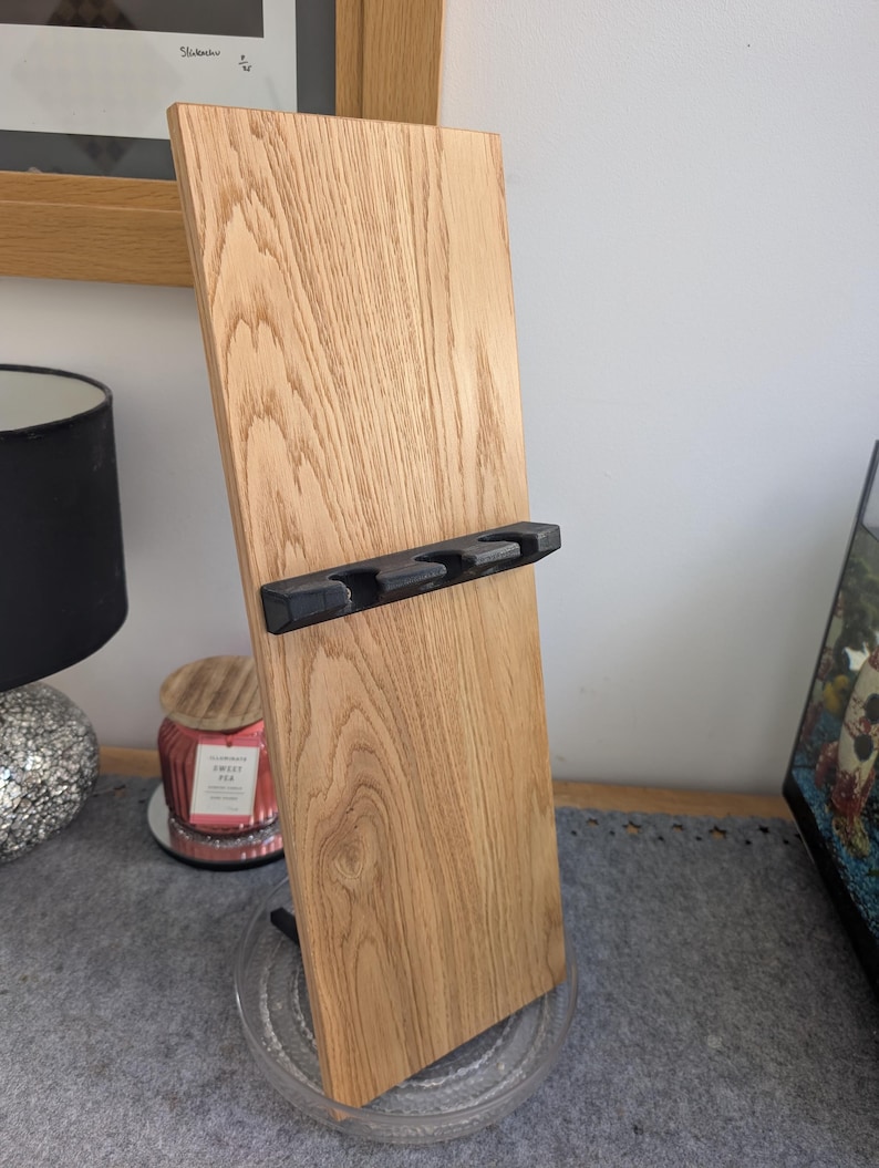 May include: A wooden stand with a black metal holder for four items. The stand is made of light wood with a natural grain pattern.