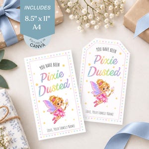 May include: Two rectangular gift tags featuring the text 'YOU HAVE BEEN PIXIE DUSTED' in rainbow gradient lettering. Each tag displays a cartoon fairy with blonde hair, pink wings, and a wand, surrounded by yellow stars. Includes 8.5 inch by 11 inch A4 text.