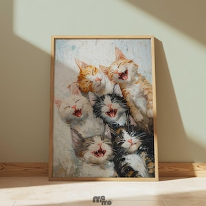 May include: A framed print featuring a group of six smiling kittens. The kittens have various coat colors, including orange, white, black, and gray. The artwork has a painterly style, with visible brushstrokes and soft colors. The frame is made of light-colored wood.