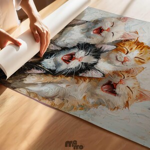 May include: A colorful painting of four yawning cats, with open mouths and closed eyes. The cats are in shades of white, orange, and black. The artwork is being unrolled on a wooden surface.