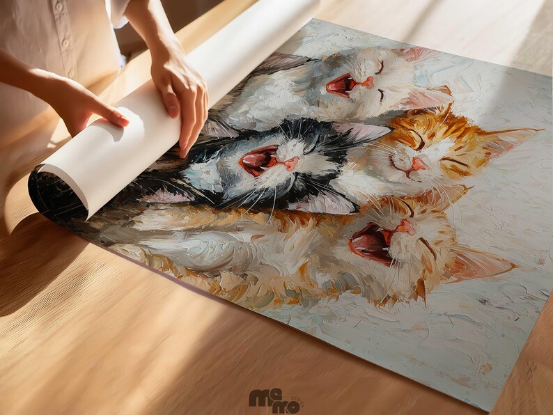 May include: A colorful painting of four yawning cats, with open mouths and closed eyes. The cats are in shades of white, orange, and black. The artwork is being unrolled on a wooden surface.