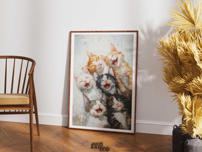 May include: A framed art print featuring a group of six laughing cats. The cats have various fur colors, including orange, black, white, and gray. The artwork is displayed in a room with a wooden floor and a chair.