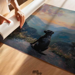 Pode incluir: Uma impress&atilde;o de arte enrolada com um c&atilde;o preto a contemplar uma cordilheira ao p&ocirc;r do sol. A impress&atilde;o est&aacute; a ser desenrolada numa superf&iacute;cie de madeira. A obra de arte tem um estilo pict&oacute;rico com cores suaves e uma atmosfera serena.