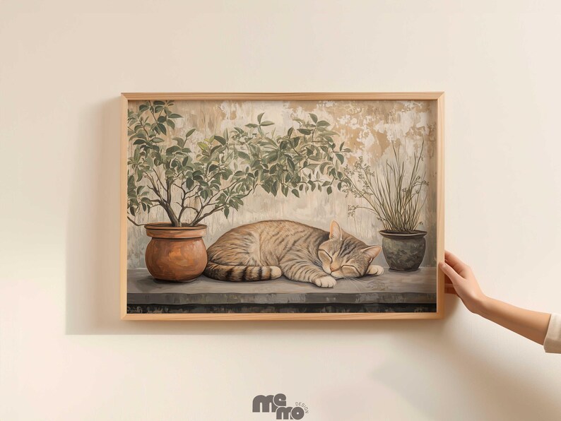 May include: A framed print featuring a sleeping tabby cat. The cat rests on a ledge, with potted plants on either side. The artwork has a neutral color palette with a vintage aesthetic, and is set against a textured background.