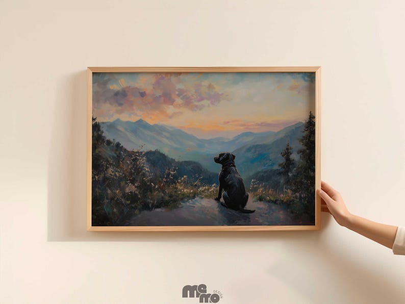 Pode incluir: Pintura de paisagem emoldurada com um c&atilde;o preto sentado numa colina, com vista para uma cordilheira ao p&ocirc;r do sol. A obra de arte tem uma moldura de madeira natural e &eacute; exibida numa parede branca.