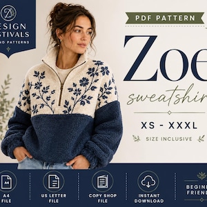 May include: A PDF sewing pattern for the Zoe sweatshirt, featuring a two-tone design with a cream-colored upper section adorned with dark blue floral embroidery and a solid dark blue lower section. The pattern includes sizes XS to XXXL.