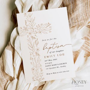 May include: Cream baptism invitation with a floral cross design. The text reads "Join us for the baptism of our daughter Emily Lou" with event details. The invitation is from Honey Paperie.