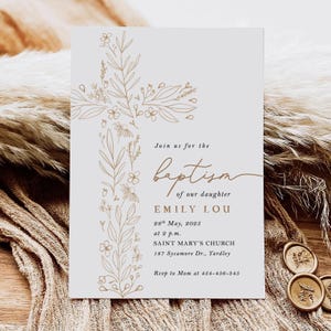 May include: A baptism invitation card featuring a gold floral cross on a pale grey background. The text reads "Join us for the baptism of our daughter Emily Lou" with date, time, and location details. RSVP information is also included.