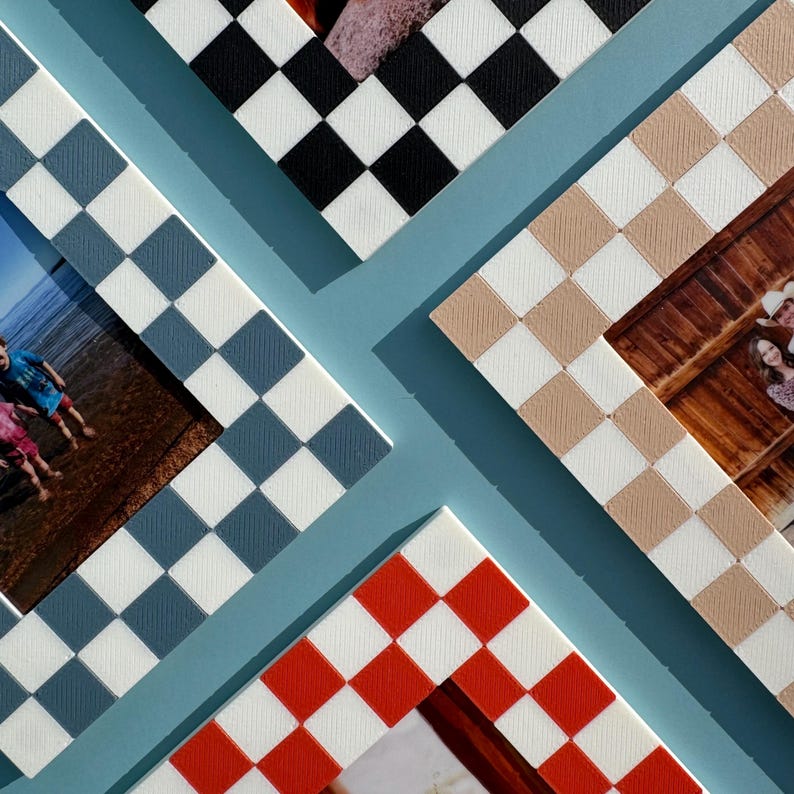 May include: An overhead shot of four photo frames with checkerboard patterns in black, tan, red, and blue. The frames are arranged on a light blue background, with photos visible inside the frames. The frames are a decorative element.