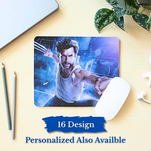 May include: Rectangular mousepad featuring a superhero image with claws extended. The mousepad has a blue background and the text "16 Design Personalized Also Availble" in a blue banner. A white computer mouse is next to the mousepad.