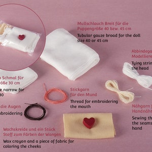 Pu&ograve; includere: Un set di forniture per la creazione di bambole che include due pezzi di garza tubolare bianca, uno stretto e uno largo, un rocchetto di filo bianco, un rocchetto di filo crema, un rocchetto di filo rosso, un rocchetto di filo nero, un piccolo pezzo di stoffa beige, un bottone rosso a forma di cuore e un pastello di cera rosso. Il testo sull'immagine recita: "Mullschlauch Breit f&uuml;r die Puppengr&ouml;&szlig;e 40 bzw. 45 cm Tubular gauze broad for the doll size 40 or 45 cm Abbindegarn zum Modellieren des Kopfes Tying string for sculpting the head Mullschlauch Schmal f&uuml;r die Puppengr&ouml;&szlig;e 30 cm Tubular gauze narrow for the doll size 30 Stickgarn f&uuml;r die Augen Thread for embroidering the eyes Wachskreide und ein St&uuml;ck Stoff zum F&auml;rben der Wangen Wax crayon and a piece of fabric for coloring the cheeks Stickgarn f&uuml;r den Mund Thread for embroidering the mouth N&auml;hgarn f&uuml;r die Handn&auml;hte Sewing thread for the seams sewn by hand"