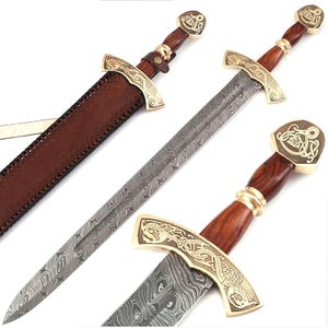 May include: A Viking sword with a patterned steel blade and a wooden handle. The sword has gold-coloured crossguards and pommel with detailed designs. A brown leather sheath is also visible.